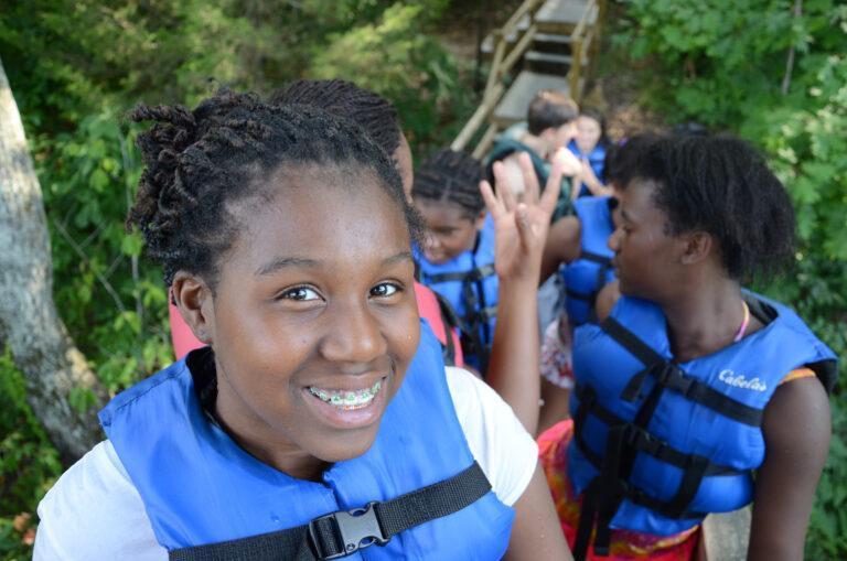 campers at Spring Valley lake in blue life jackets at Deer Run Camps & Retreats