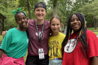 Deer Run female summer camp staff smiling with 3 campers