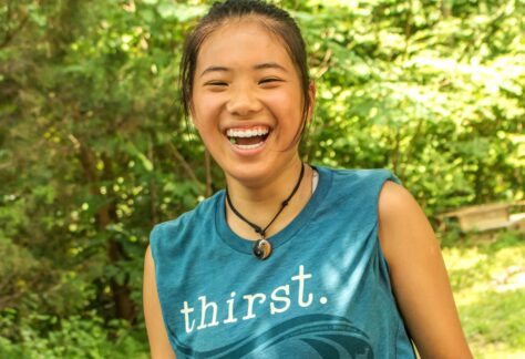 smiling summer staffer wearing thirst tshirt at Deer Run Camps & Retreats