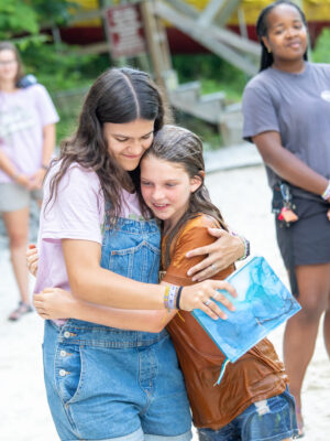 Girl summer staffer hugging her camper that was just baptized.