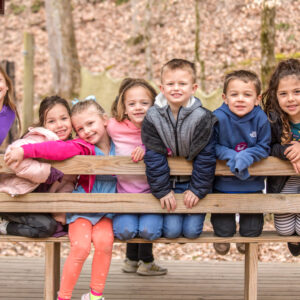 Several Winter Day Campers smiling for a picture at the Archery/BB range at Deer Run Camps & Retreats Winter Camp.