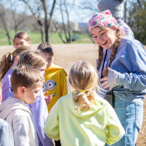 Counselor smiling and talking with campers at IGNITE Spring Break Day Camp