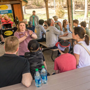 Female full time camp staff greets and tells guests about summer camps at Deer Run Camps & Retreats Open House event.