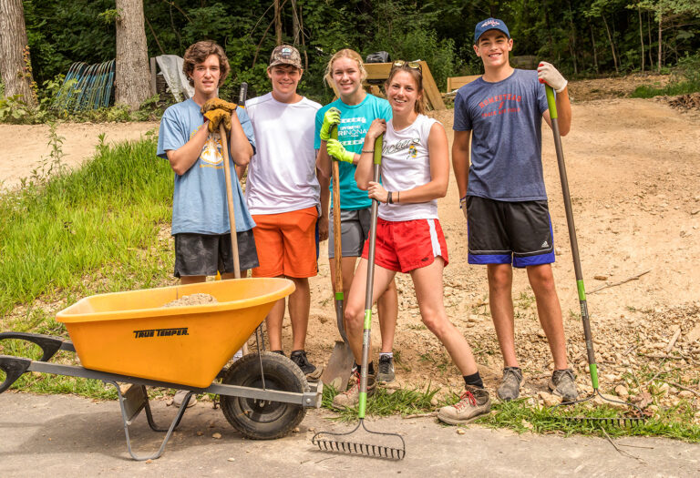 volunteer group with rakes and wheelbarrow at Deer Run Camps & Retreats Spring Serve Day