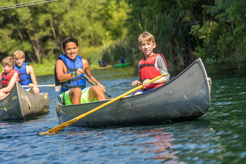 2 boy overnight camper canoeing at Spring Valley Lake at Deer Run Camps & Retreats